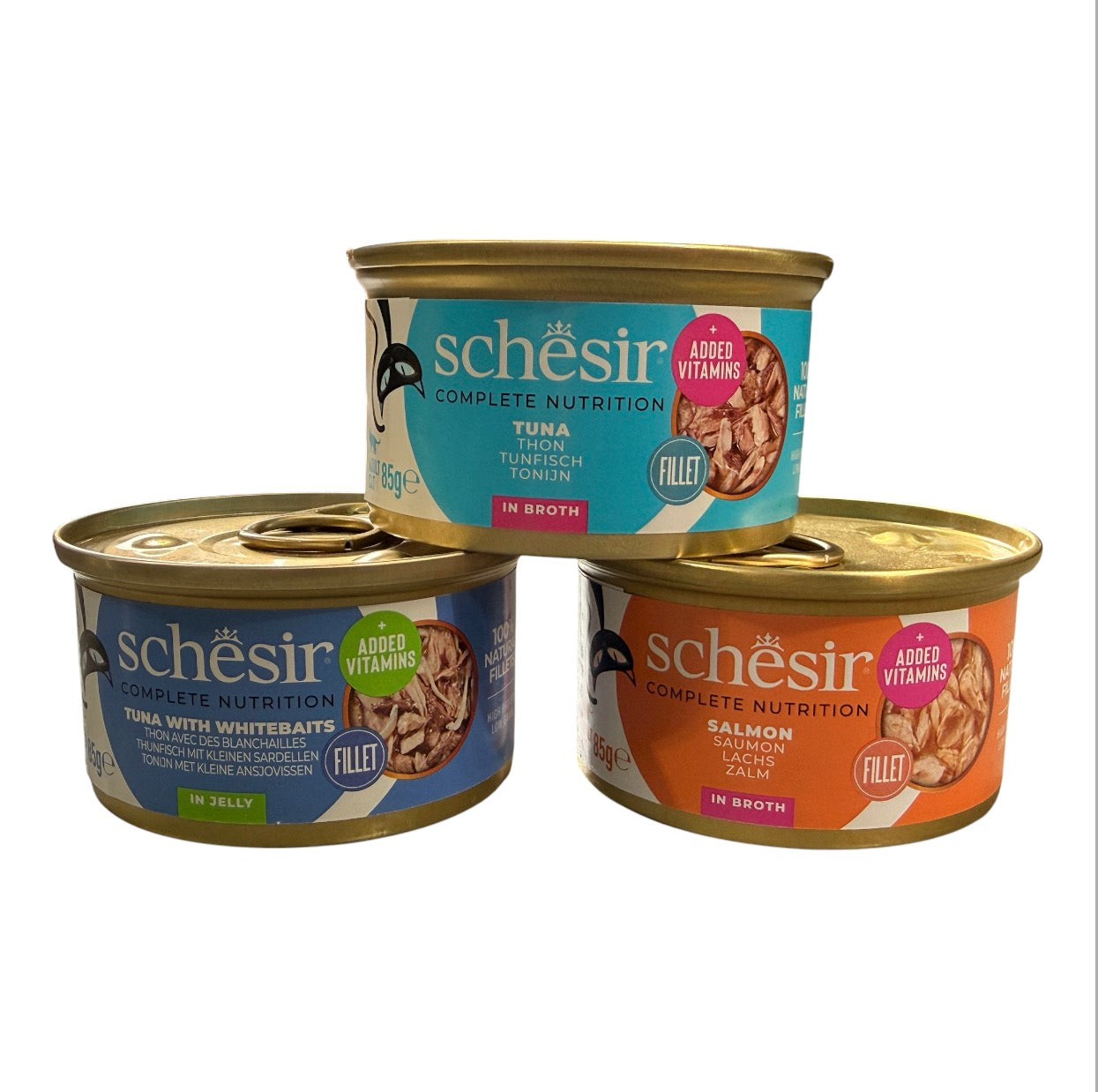 Three Schésir canned pet food products arranged in a pyramid on a white background: a top can of tuna with a blue label, a left can of salmon with a blue label, and a right can of salmon with an orange label.